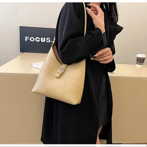 Détail du sac hobo beige avec matelassage géométrique et boucle métallique sur le modèle