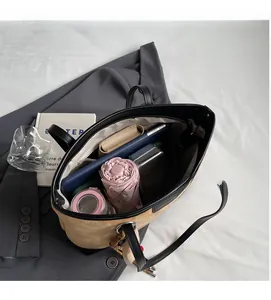 Top view of spacious interior in two-tone tote bag holding tablet, umbrella, and essentials