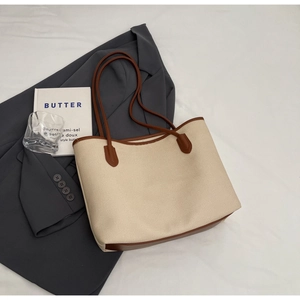 Minimalist beige canvas tote bag with brown leather handles for autumn fashion