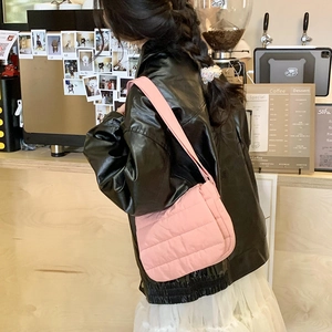 Pink quilted shoulder bag with fluffy down texture and wide strap on casual model