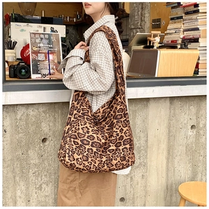 Close-up of large leopard print canvas tote bag styled in a cafe setting
