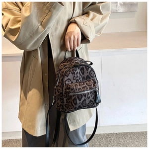 Detalle de mini mochila con estampado de leopardo, cremalleras plateadas y correas