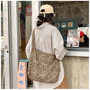 Detailed back view of a large leopard print canvas tote bag styled for casual streetwear