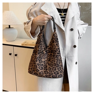Détail du sac cabas léopard en forme de croissant avec poignée en cuir noir élégant
