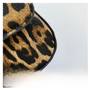Close-up of leopard print PU leather texture with detailed embossed grain and black edge finish