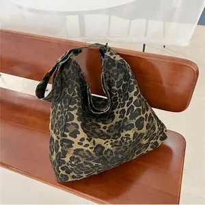 Sac fourre-tout en toile à imprimé léopard posé sur un banc en bois de style rétro