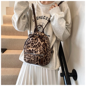 Mini mochila de leopardo en piel sintética sobre modelo con lazo y detalle de cremallera