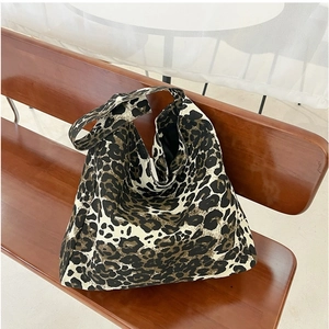 Sac fourre-tout chic en toile sergé léopard avec bandoulière sur un banc en bois