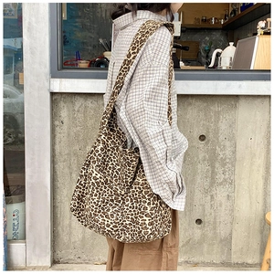 Macro detail of the leopard print canvas tote bag with a wide shoulder strap design