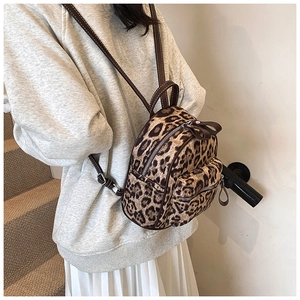 Detalle de una mini mochila con estampado de leopardo y ribete de cuero marrón en modelo