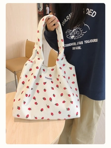 Vue détaillée d'un sac cabas en velours côtelé blanc avec imprimé fraise et étiquette