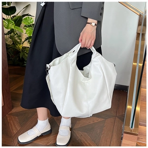 Close-up of white pleated tote bag showing large capacity and premium lychee texture