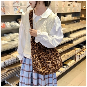 Close-up of leopard print cotton shoulder bag featuring a wide strap in a cozy bookstore setting