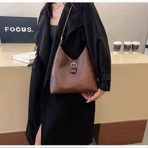 Détail d'un sac cabas en cuir PU marron avec gaufrage géométrique et brides à boucle argentée
