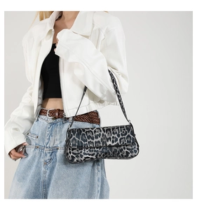 Detailed close-up of leopard print shoulder bag worn by model with white leather jacket