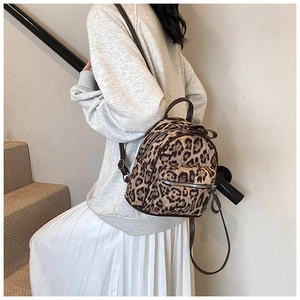 Detalle de una mini mochila de cuero sintético con estampado de leopardo en una modelo