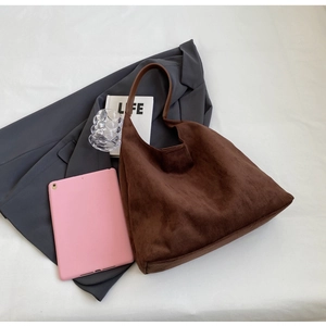 Brown suede hobo tote bag flat lay with a blazer and magazine for a work-ready scene