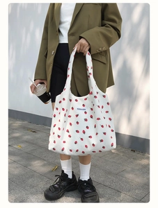 Vue street style d'un sac cabas en velours côtelé blanc avec imprimés fraises et larges anses