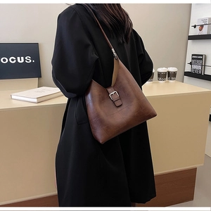 Gros plan détaillé du sac bandoulière en cuir PU marron foncé avec texture vintage et boucle