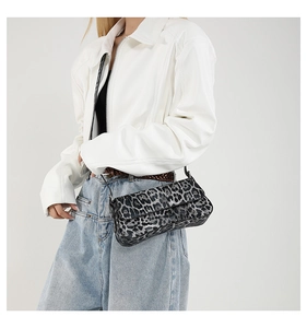 Close-up of leopard print shoulder bag styled with a white PU jacket and denim jeans