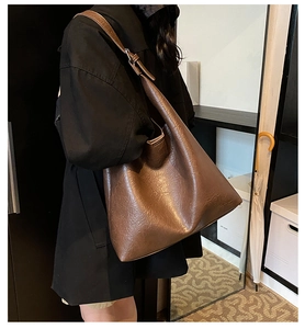 Detail showing the vintage dark brown PU leather texture and adjustable wide shoulder strap