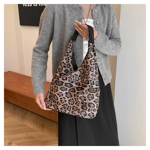 Sac à main chic en cuir PU à imprimé léopard porté par un mannequin dans une pièce sobre