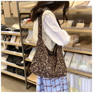 Detail shot of large capacity leopard print canvas tote bag on a stylish store shelf