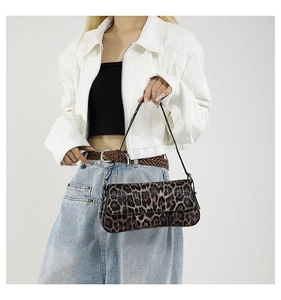Detail of trendy leopard print PU leather baguette bag with a slim strap worn by a model