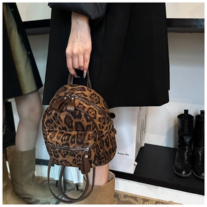 Vista detallada de mini mochila con estampado de leopardo y cremalleras plateadas