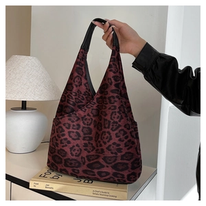 Détail d'un sac à main léopard rouge avec poignée en cuir dans un décor élégant