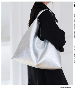 Detail of silver metallic tote bag with sleek pleated texture and geometric design