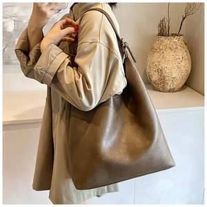 Detail view of deep brown vintage textured tote bag with glossy finish and wide strap
