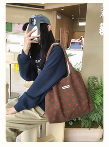 Gros plan détaillé du sac cabas en velours côtelé marron à motifs fraises brodés