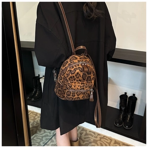 Detalle de mini mochila con estampado de leopardo, ribete de cuero y finas costuras blancas