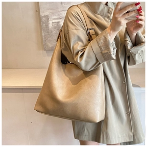 Detail view of stylish beige PU leather tote bag with subtle wrinkled texture for women