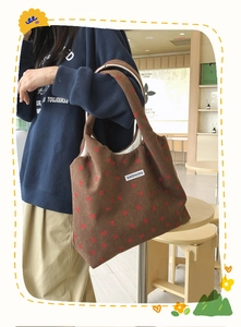 Vue détaillée du sac cabas en velours côtelé marron avec motifs fraises et étiquette