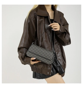 Chic black and white houndstooth shoulder bag styled with vintage brown leather jacket