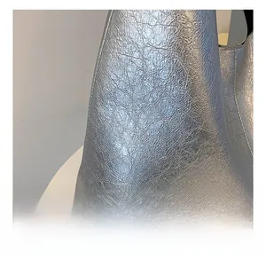 Detailed macro view showing the textured silver metallic PU fabric on a minimalist hobo bag