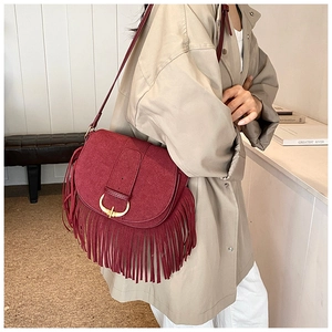 Detail view of burgundy matte PU crossbody bag with long fringe and golden metal buckle