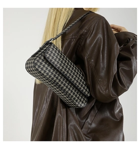 Detail of classic houndstooth pattern shoulder bag with fine leather strap and metal hardware
