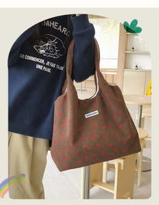 Détail d'un sac cabas en velours côtelé marron à motif fraise avec étiquette blanche