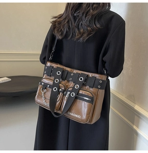 Detail of brown PU leather shoulder bag with metallic eyelets and decorative silver chain