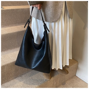 Detail of a large black PU leather Hobo tote bag with stylish pleated texture and silver buckle