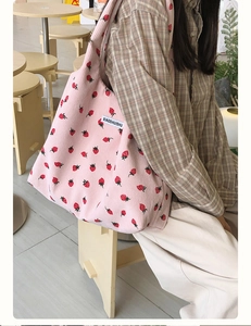 Détail du sac cabas en velours côtelé rose avec broderie fraise et étiquette