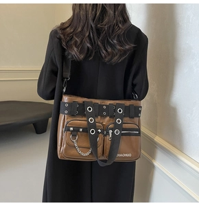 Detail of brown PU leather crossbody bag featuring metal chains and double front pockets