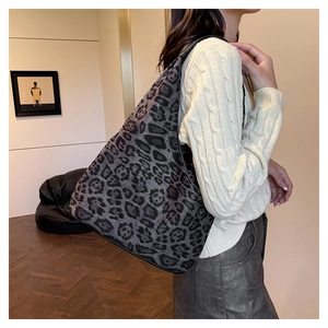 Détail du sac cabas gris à motif léopard en tissu PU porté à l'épaule sur un pull