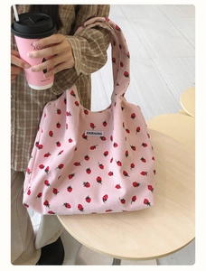 Détail du sac cabas en velours côtelé rose avec imprimé fraise et étiquette blanche