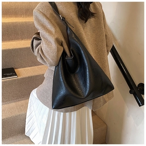 Close-up of black PU leather hobo bag with pleated texture and adjustable shoulder strap