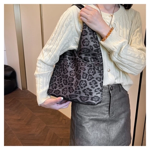 Détail d'un sac à bandoulière gris à motif léopard avec une large sangle assortie
