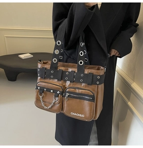 Detail of vintage brown PU leather bag featuring metal eyelets and decorative chain